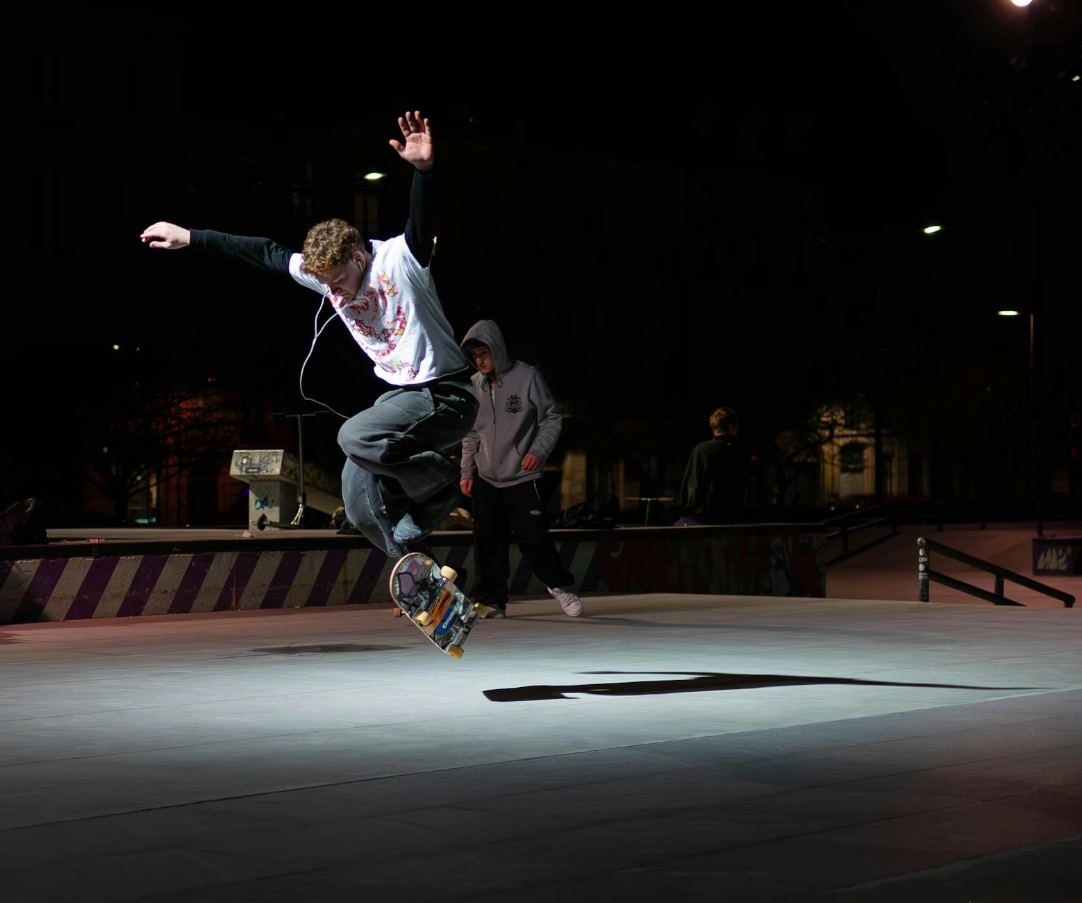 Skateboarder bei Nacht unter Lichtern